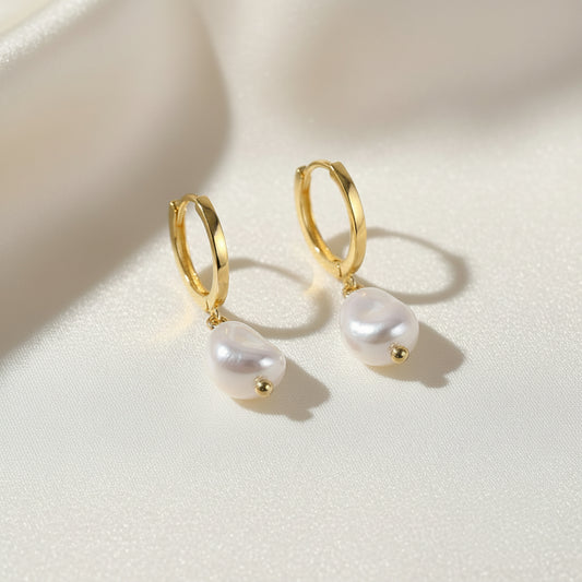 Gold hoop earrings with white pearls and 'Real Sterling Silver 925' stamp on a white background